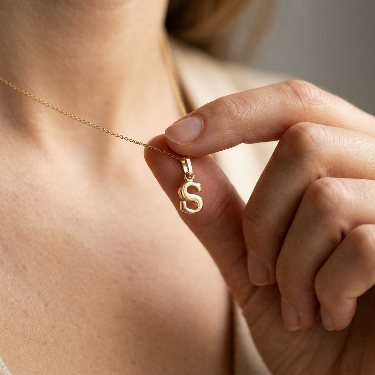 Anhänger Buchstabe S glänzend – 375er Gold, 8 × 5 mm – an einer feinen Kette getragen, zweite Lifestyle-Aufnahme in anderer Perspektive