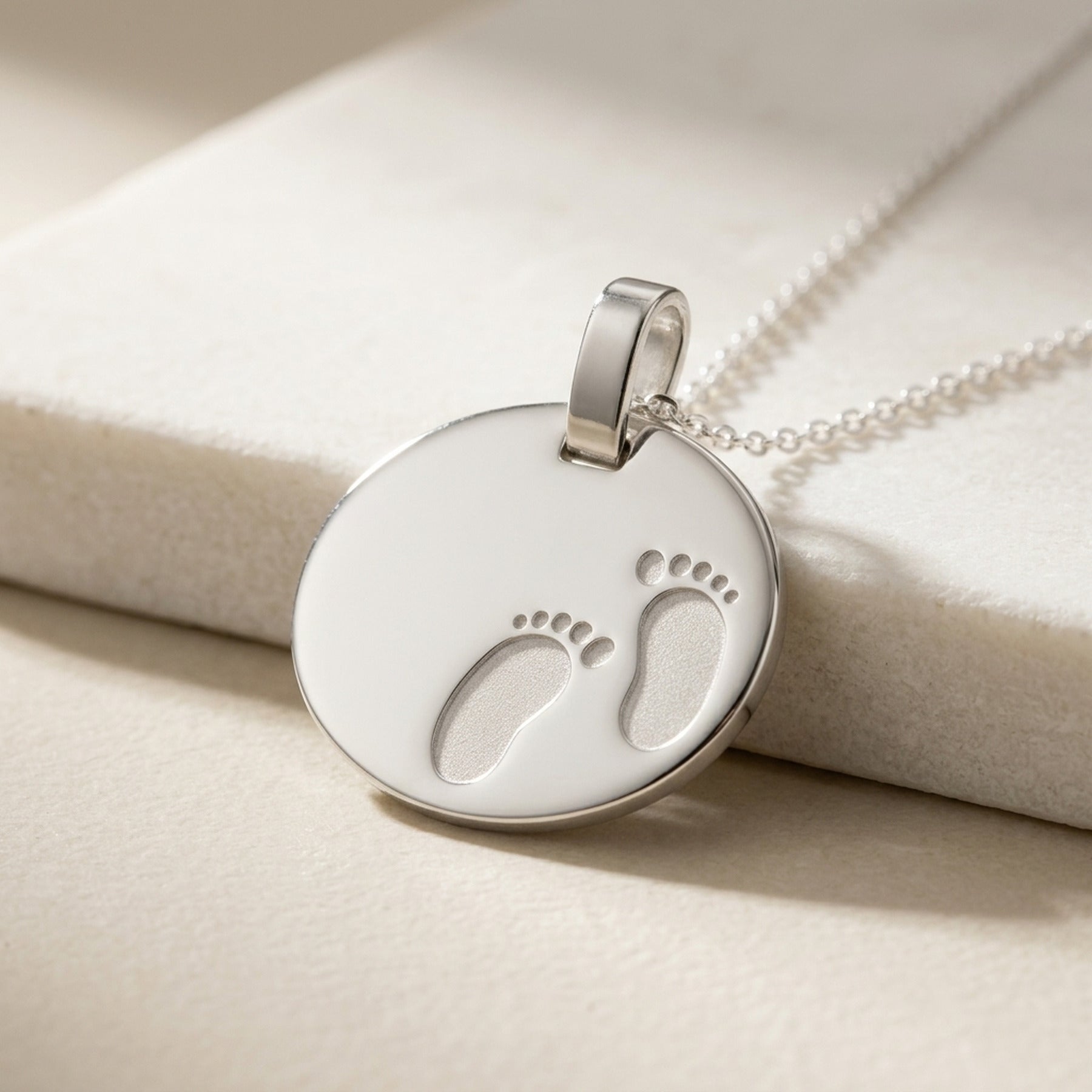 Anhänger Gravuranhänger zur Geburt Füße glänzend-matt – 925er Silber, 21 × 17 mm – Detailansicht des Anhängers vor neutralem Hintergrund