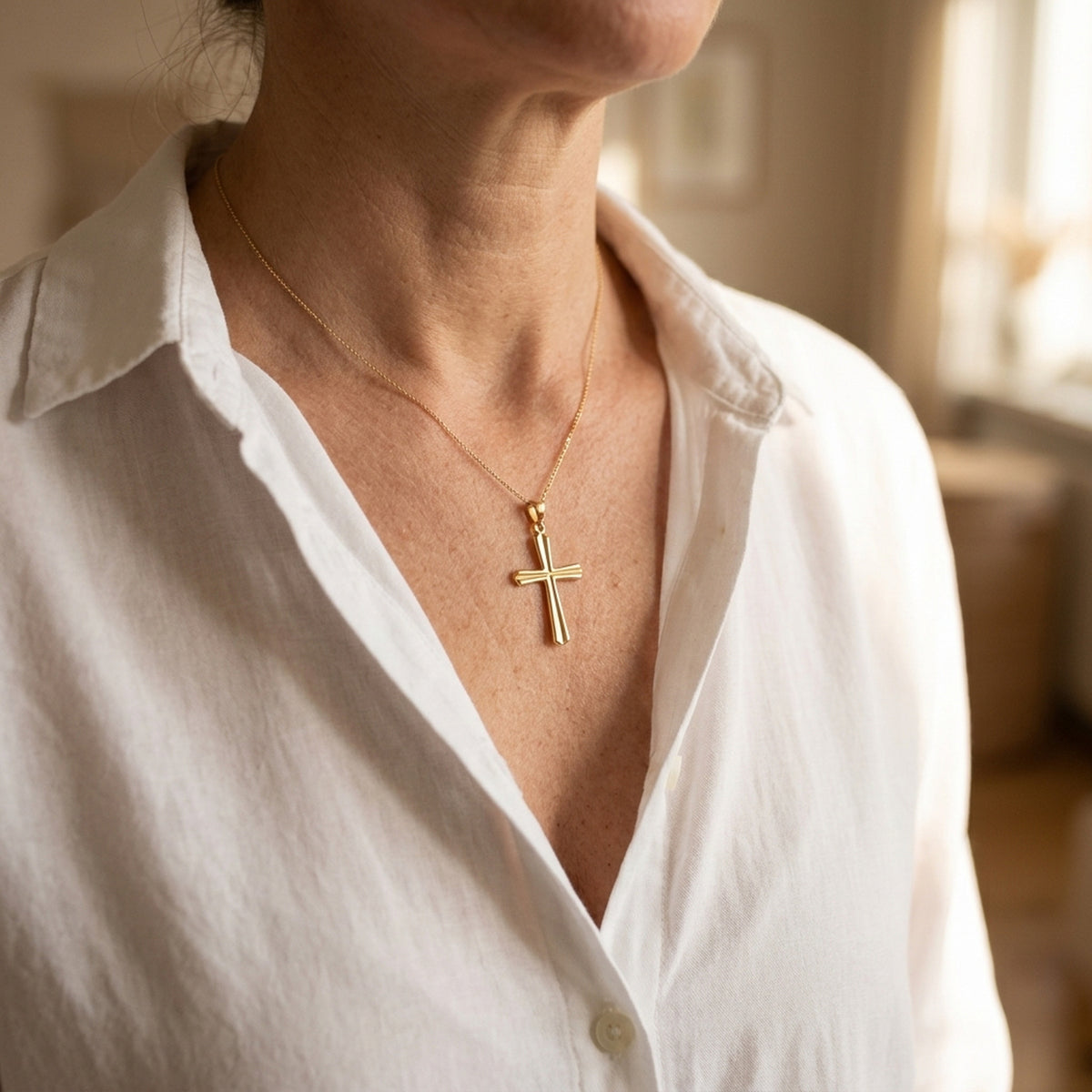 Anhänger Kreuz mit Rille in Kreuzbalken – 375er Gold, 25 × 15 mm – an einer feinen Kette getragen, natürliche Lifestyle-Aufnahme