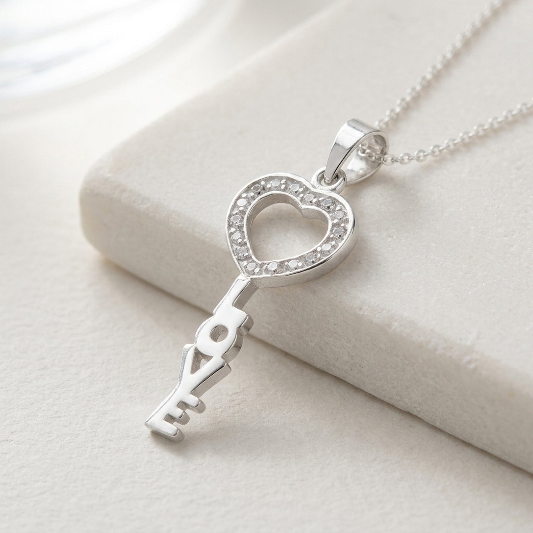 Anhänger Schlüssel LOVE mit Zirkonia glänzend – 925er Silber, 28 × 12 mm – Detailansicht des Anhängers vor neutralem Hintergrund