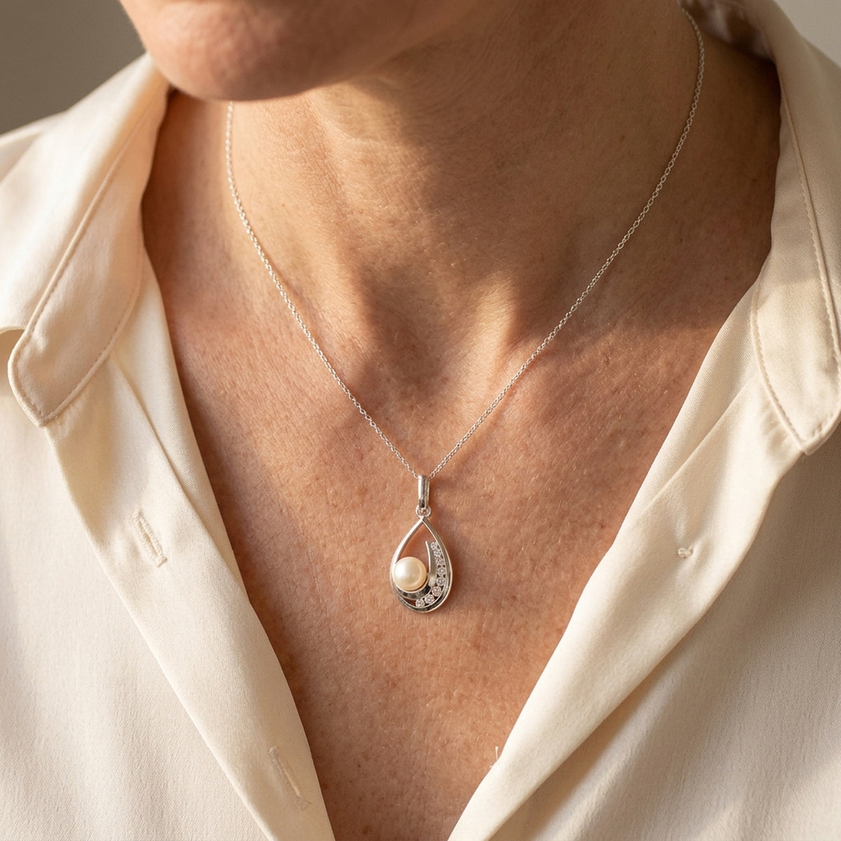 Anhänger mit Süßwasserzuchtperle und Zirkonia – 925er Silber, 25 × 10 mm – an einer feinen Kette getragen, natürliche Lifestyle-Aufnahme