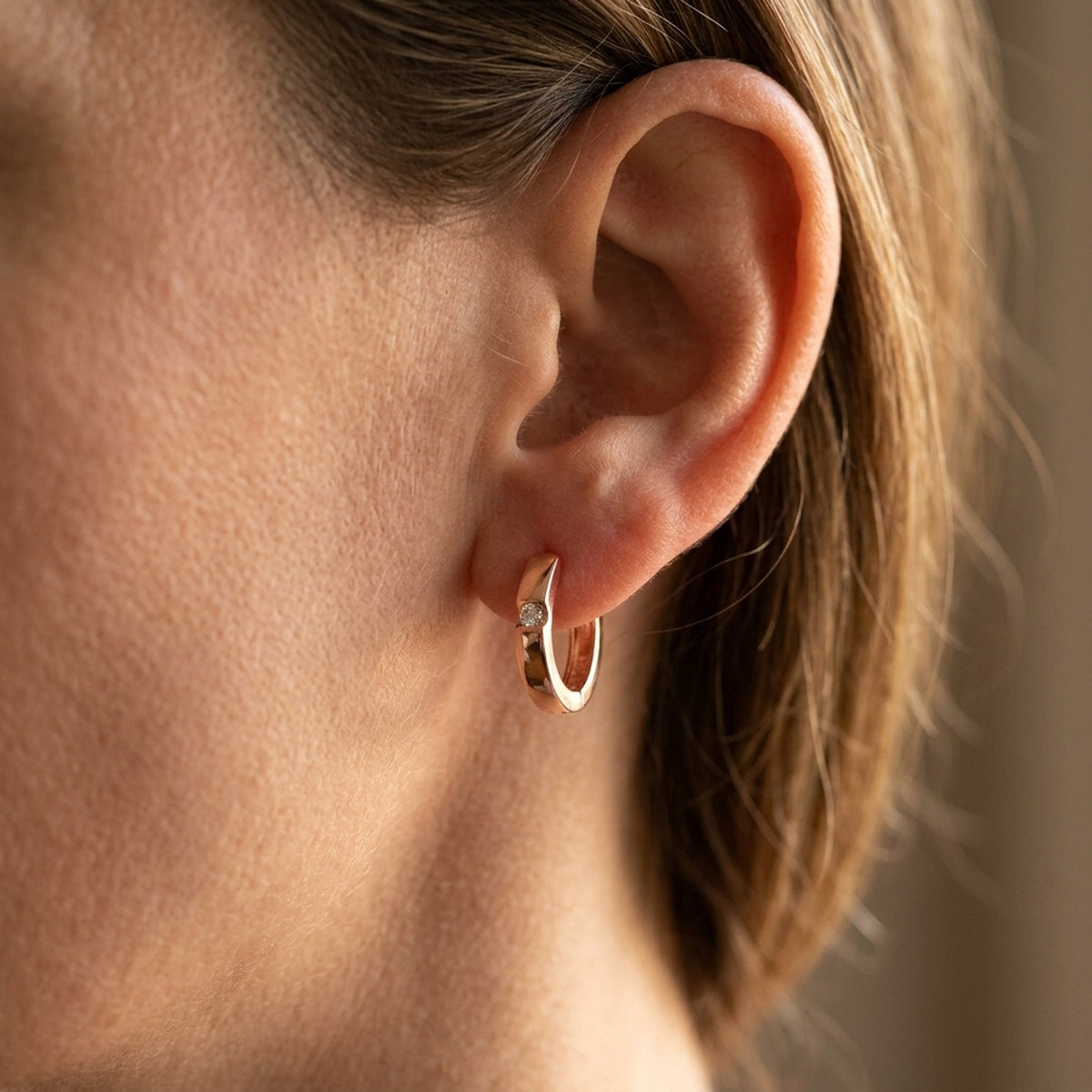Creolen mit Zirkonia rotvergoldet – 925er Silber, 12 × 2 mm – am Ohr getragen, zweite Lifestyle-Aufnahme in anderer Perspektive