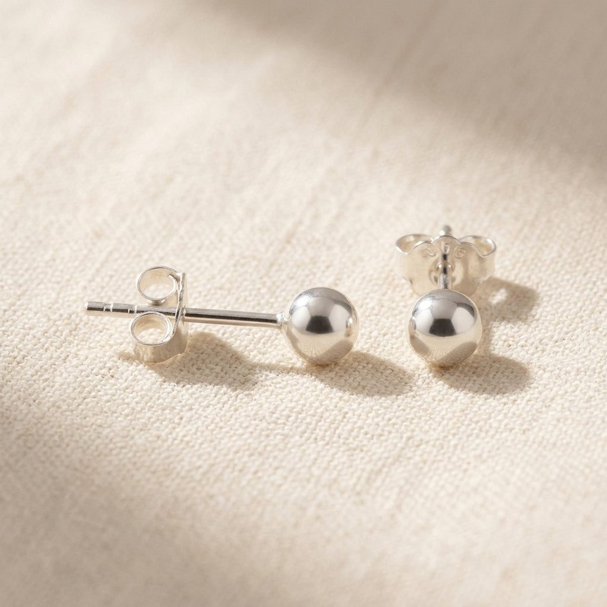 Ohrstecker Kugel glänzend – 925er Silber, 4 mm – Detailansicht des Ohrschmucks vor neutralem Hintergrund