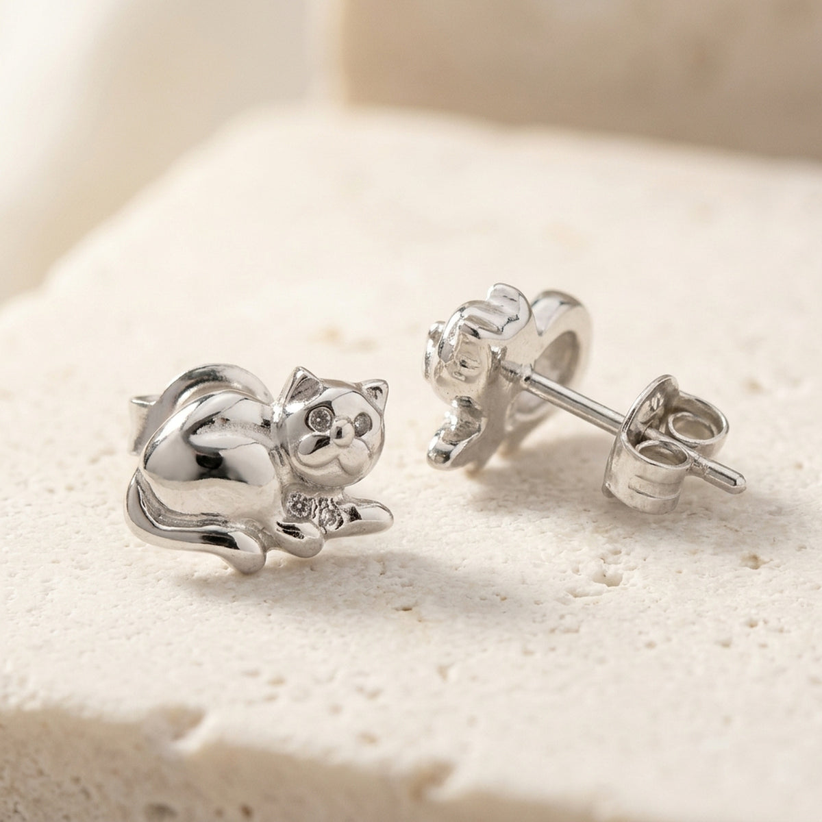 Ohrstecker liegende Katze glänzend rhodiniert – 925er Silber, 7 × 10 mm – Detailansicht des Ohrschmucks vor neutralem Hintergrund