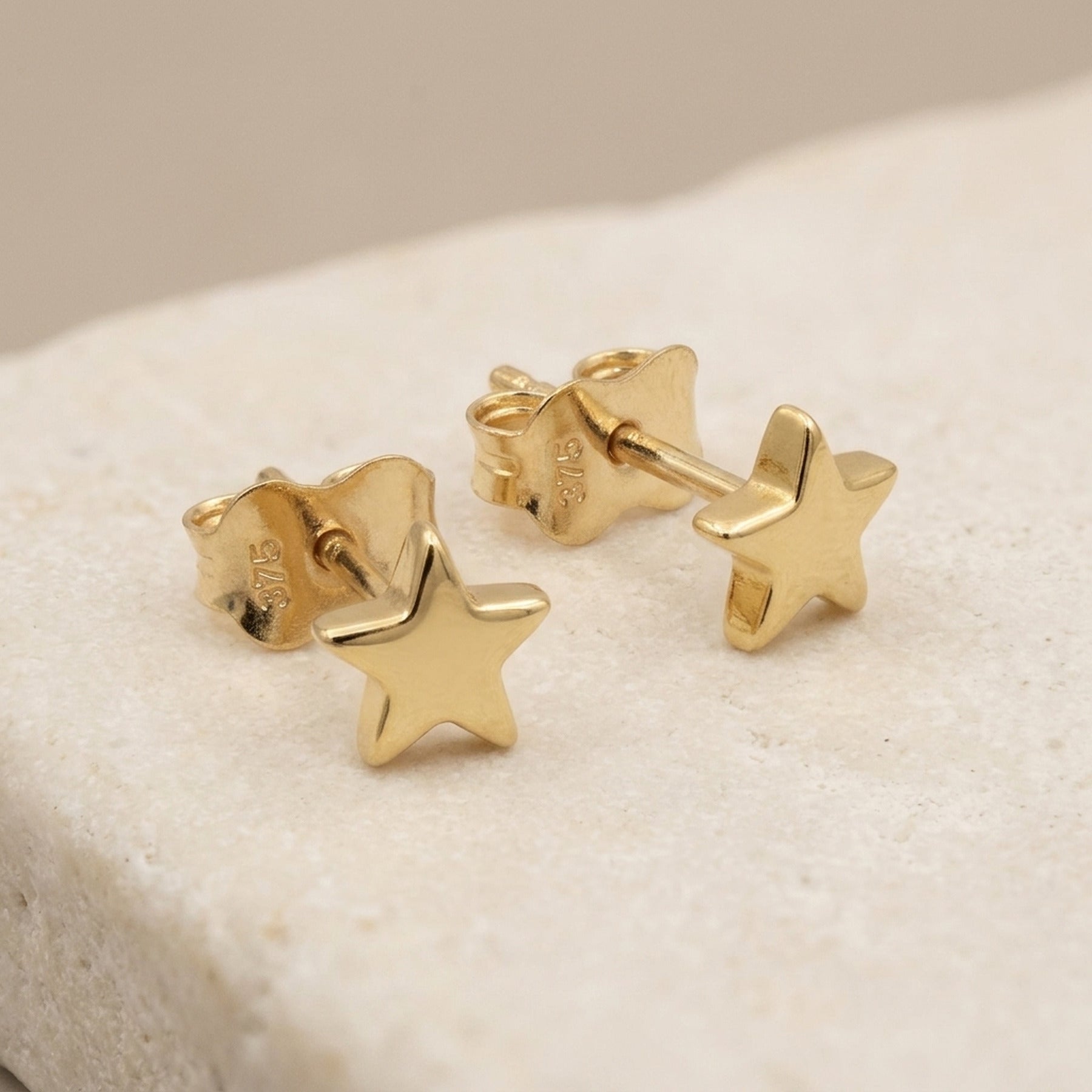 Ohrstecker Stern glänzend – 375er Gold, 5 mm – Detailansicht des Ohrschmucks vor neutralem Hintergrund