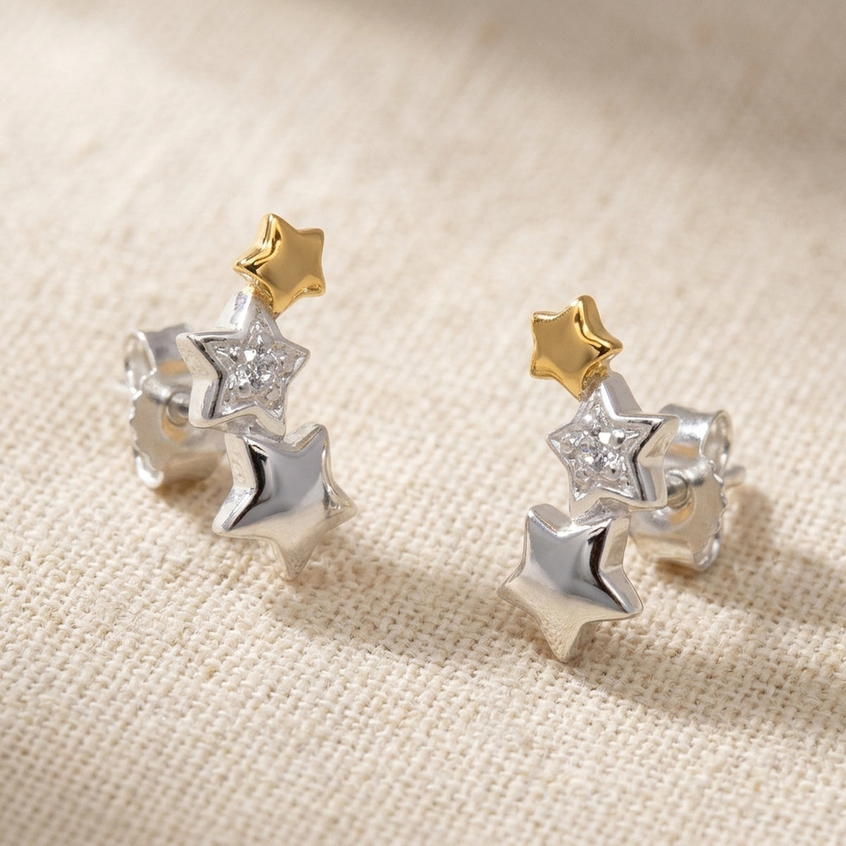 Ohrstecker Sternentrio mit Zirkonia bicolor – 925er Silber, 11 × 5 mm – Detailansicht des Ohrschmucks vor neutralem Hintergrund