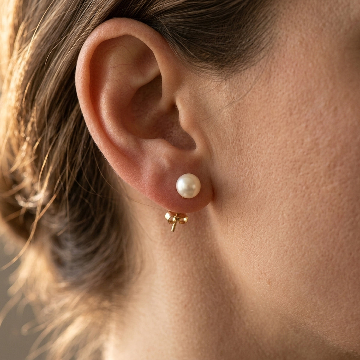 Ohrstecker mit Süßwasserzuchtperle – 375er Gold, ca. 6 mm, 0,73 g – am Ohr getragen, zweite Lifestyle-Aufnahme in anderer Perspektive