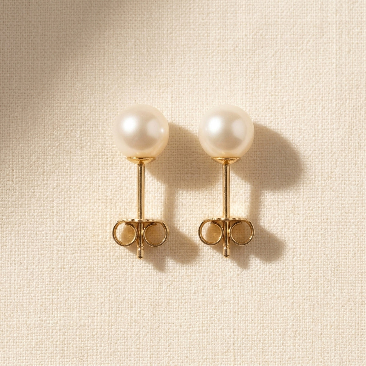 Ohrstecker mit Süßwasserzuchtperle rund – 375er Gold, ca. 5 mm – Detailansicht des Ohrschmucks vor neutralem Hintergrund