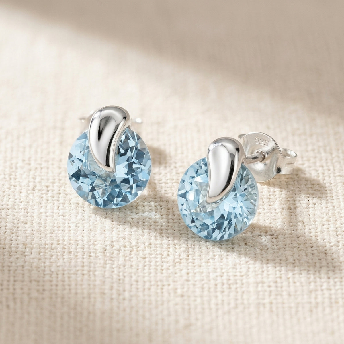 Ohrstecker mit synthetischem Aquamarin – 925er Silber, 7 × 6 mm – Detailansicht des Ohrschmucks vor neutralem Hintergrund