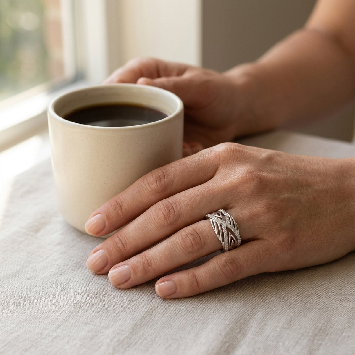 Ring mit vielen Zirkonia glänzend rhodiniert – 925er Silber, 11 mm – an der Hand getragen, natürliche Lifestyle-Aufnahme