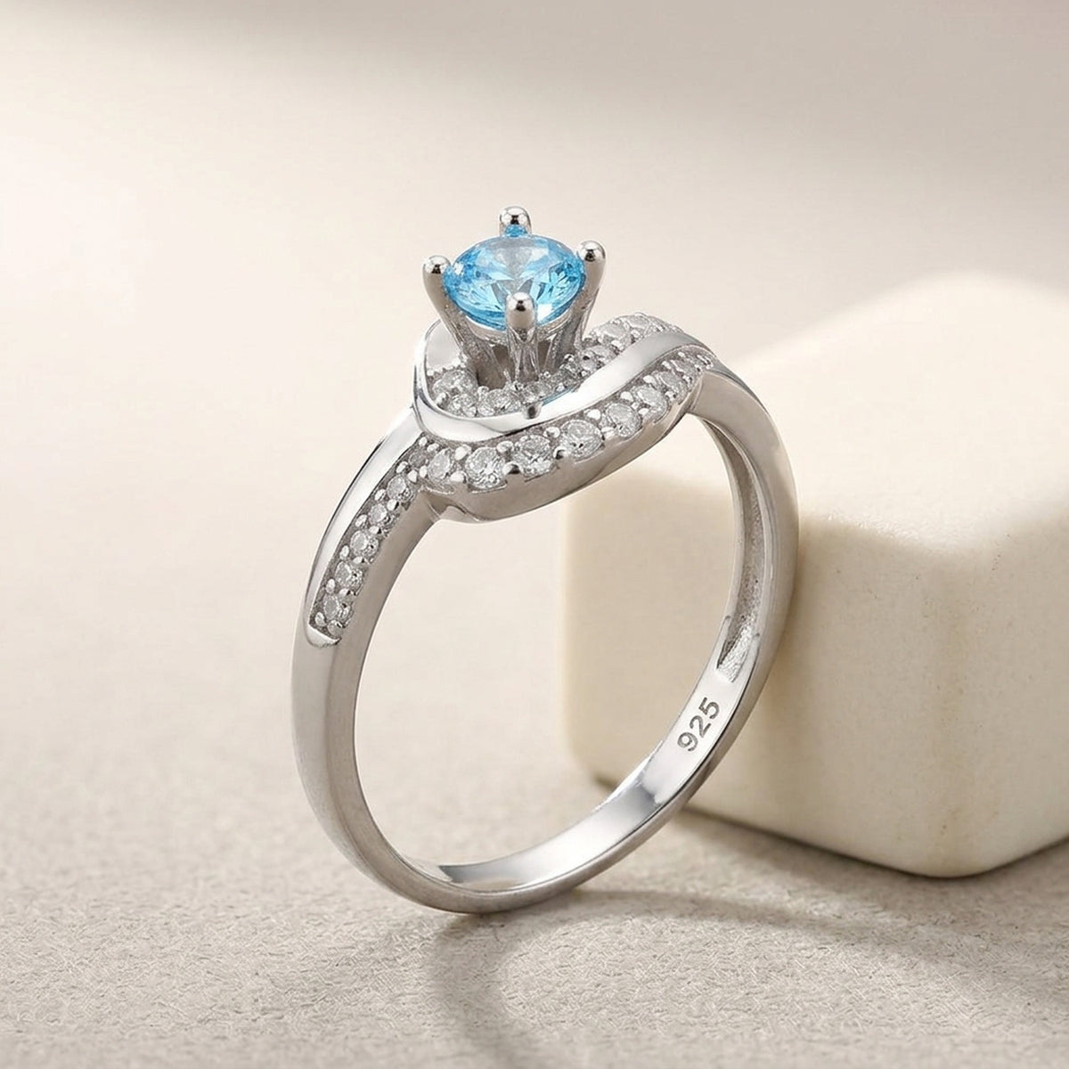 Ring mit aqua- und weißen Zirkonia glänzend rhodiniert – 925er Silber, 10 mm – Detailansicht des Rings vor neutralem Hintergrund