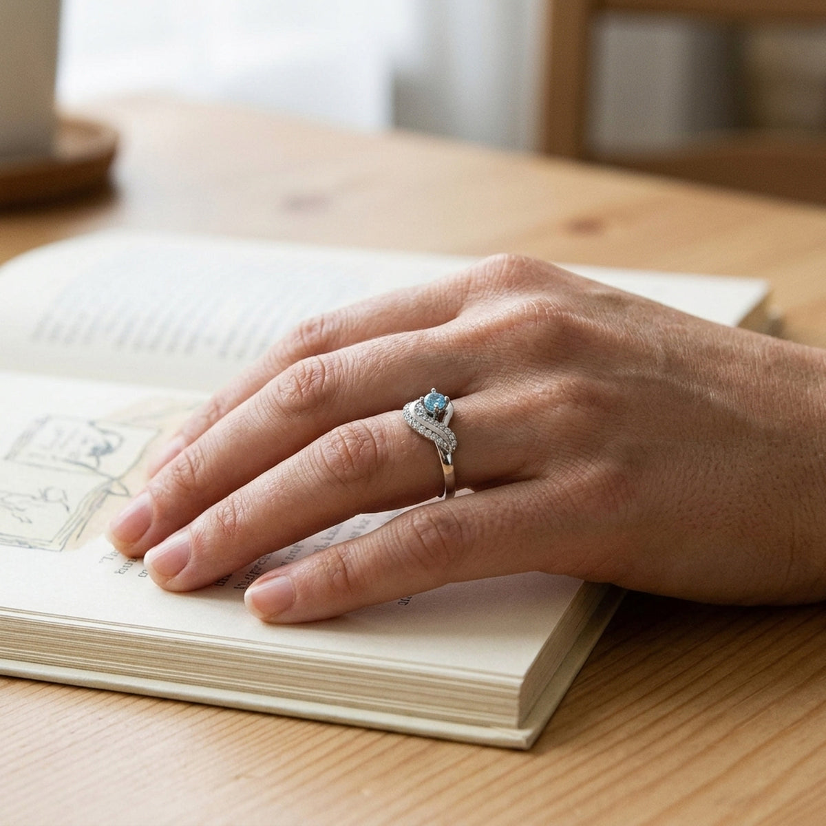Ring mit aqua- und weißen Zirkonia glänzend rhodiniert – 925er Silber, 10 mm – an der Hand getragen, natürliche Lifestyle-Aufnahme
