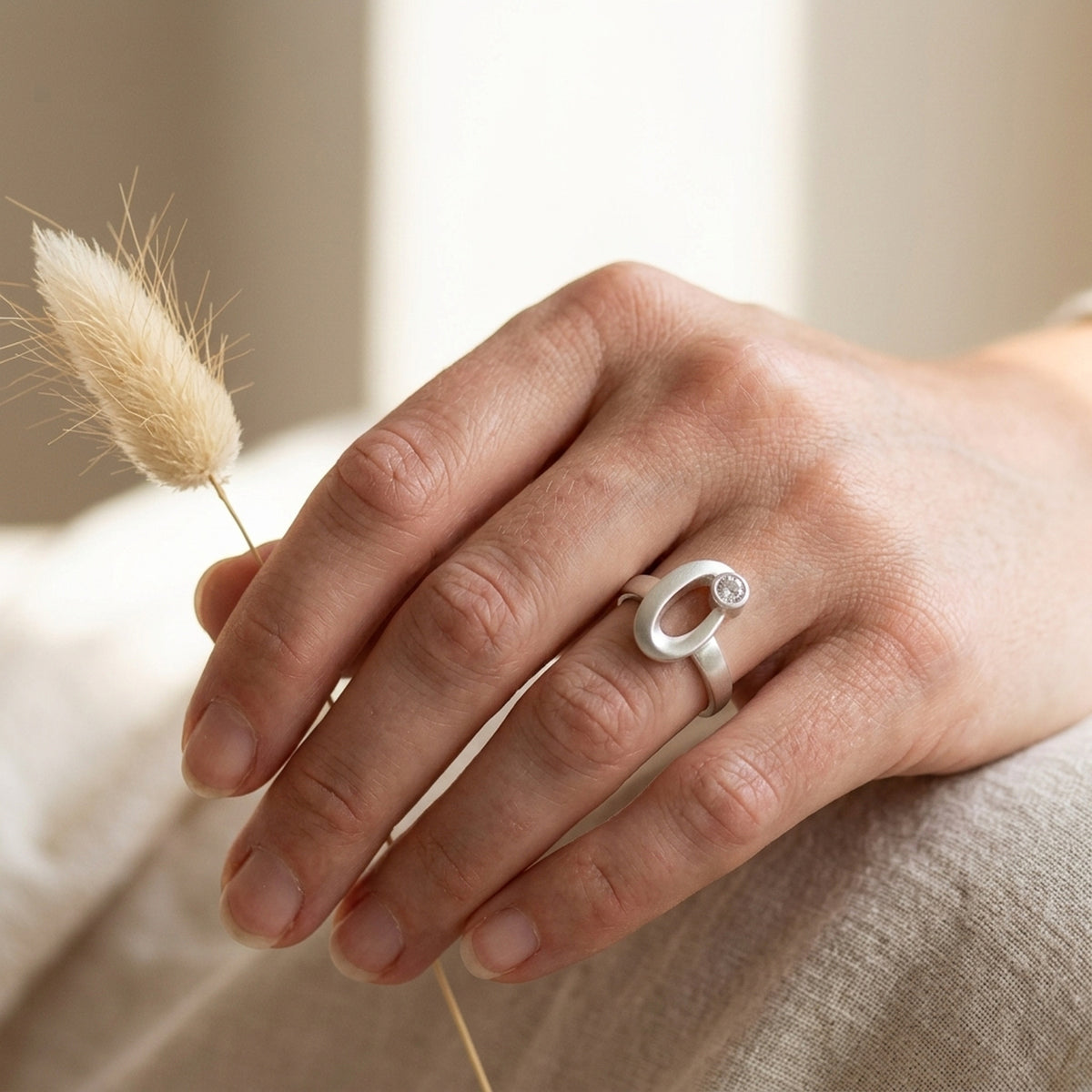 Ring mit gefasstem Zirkonia, matt-glänzend – 925er Silber, 9 mm – an der Hand getragen, zweite Lifestyle-Aufnahme in anderer Perspektive