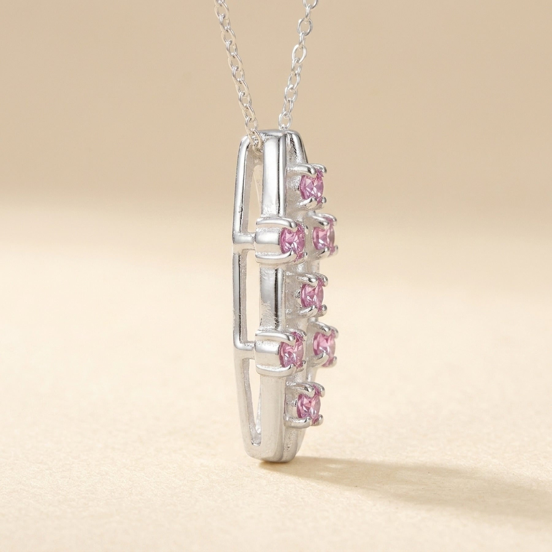 Anhänger mit 7 pinken Zirkonia – 925er Silber, 21 × 9 mm – Detailansicht des Anhängers vor neutralem Hintergrund