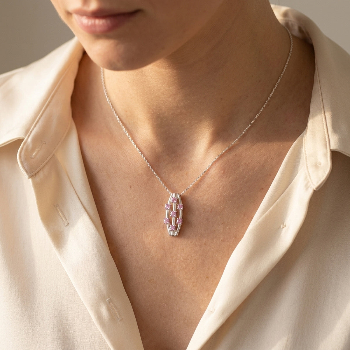 Anhänger mit 7 pinken Zirkonia – 925er Silber, 21 × 9 mm – an einer feinen Kette getragen, natürliche Lifestyle-Aufnahme