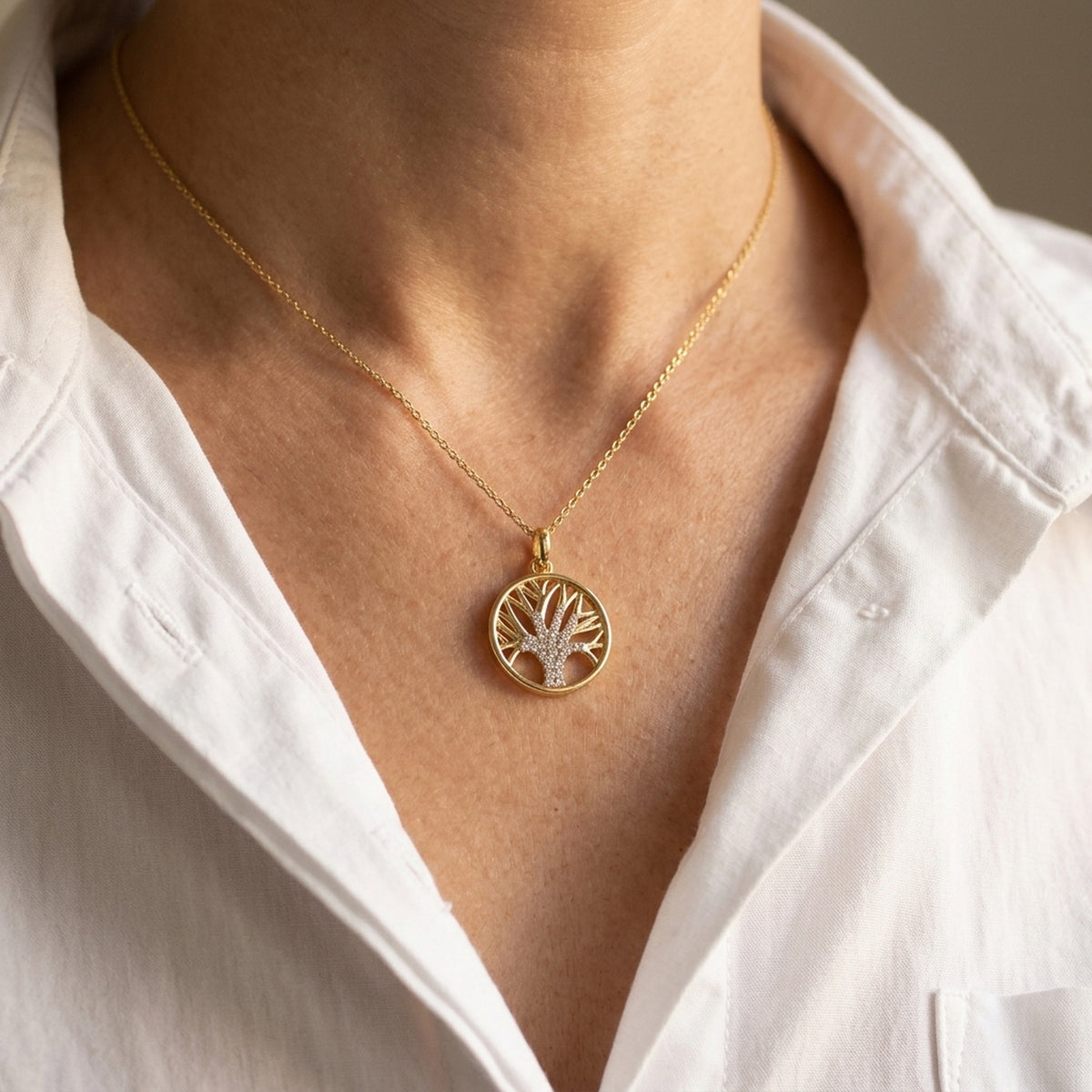 Anhänger Baum des Lebens mit Zirkonia – 375er Gold, 15 mm – an einer feinen Kette getragen, natürliche Lifestyle-Aufnahme