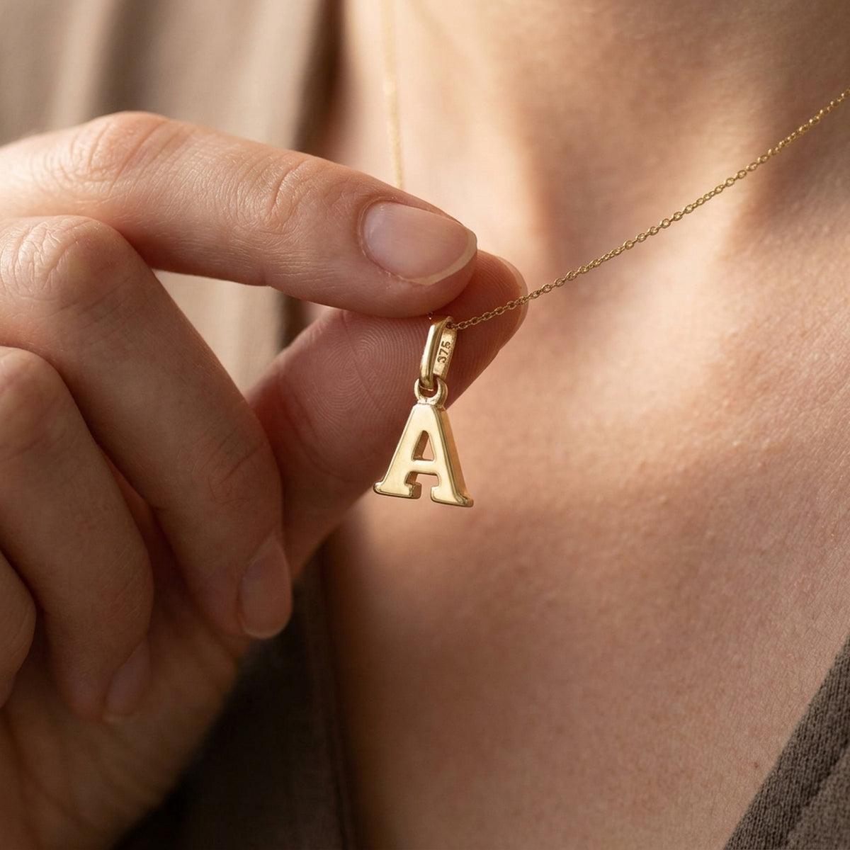 Anhänger Buchstabe A glänzend – 375er Gold, 8 × 6,5 mm – an einer feinen Kette getragen, zweite Lifestyle-Aufnahme in anderer Perspektive