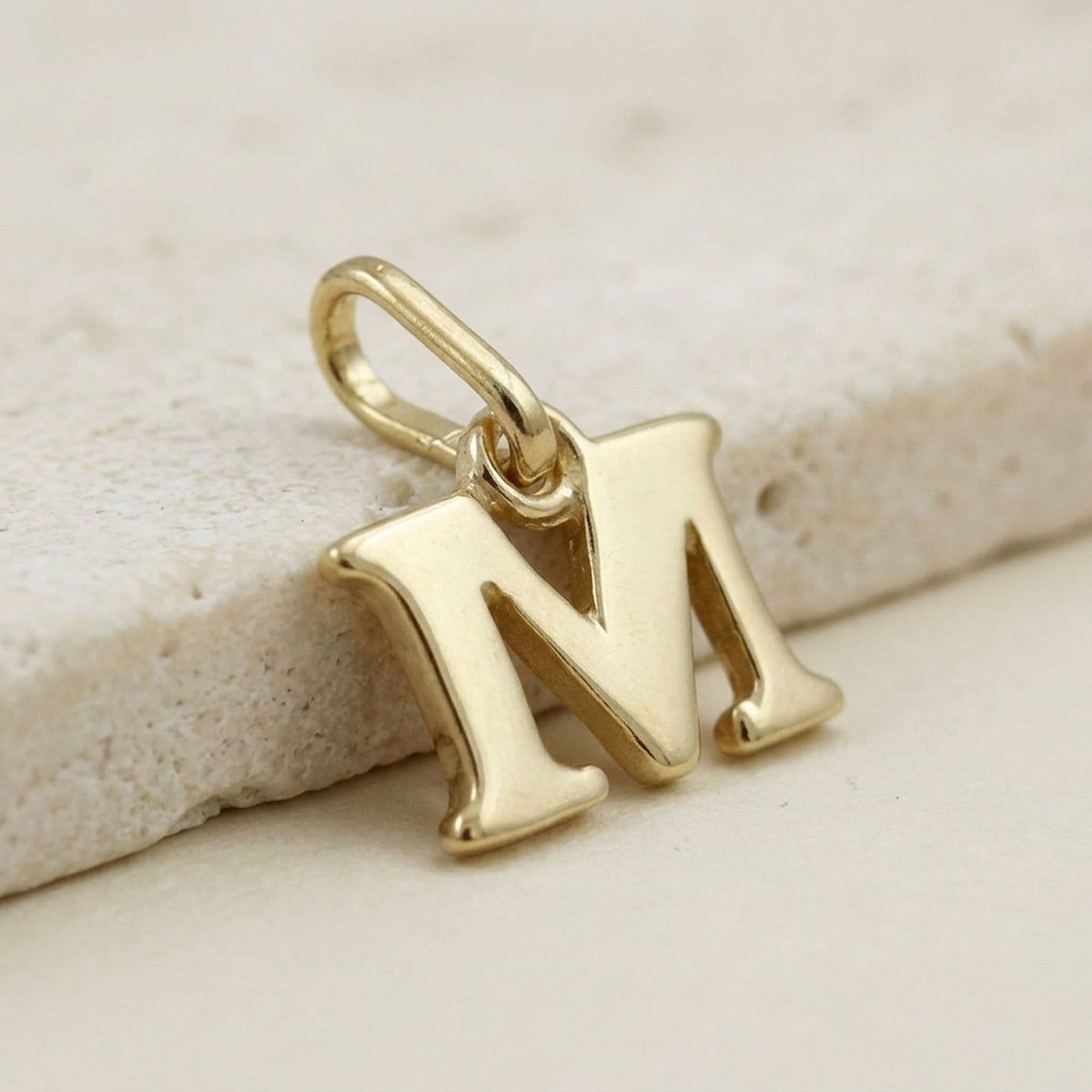 Anhänger Buchstabe M glänzend – 375er Gold, 7 × 8 mm – Detailansicht des Anhängers vor neutralem Hintergrund
