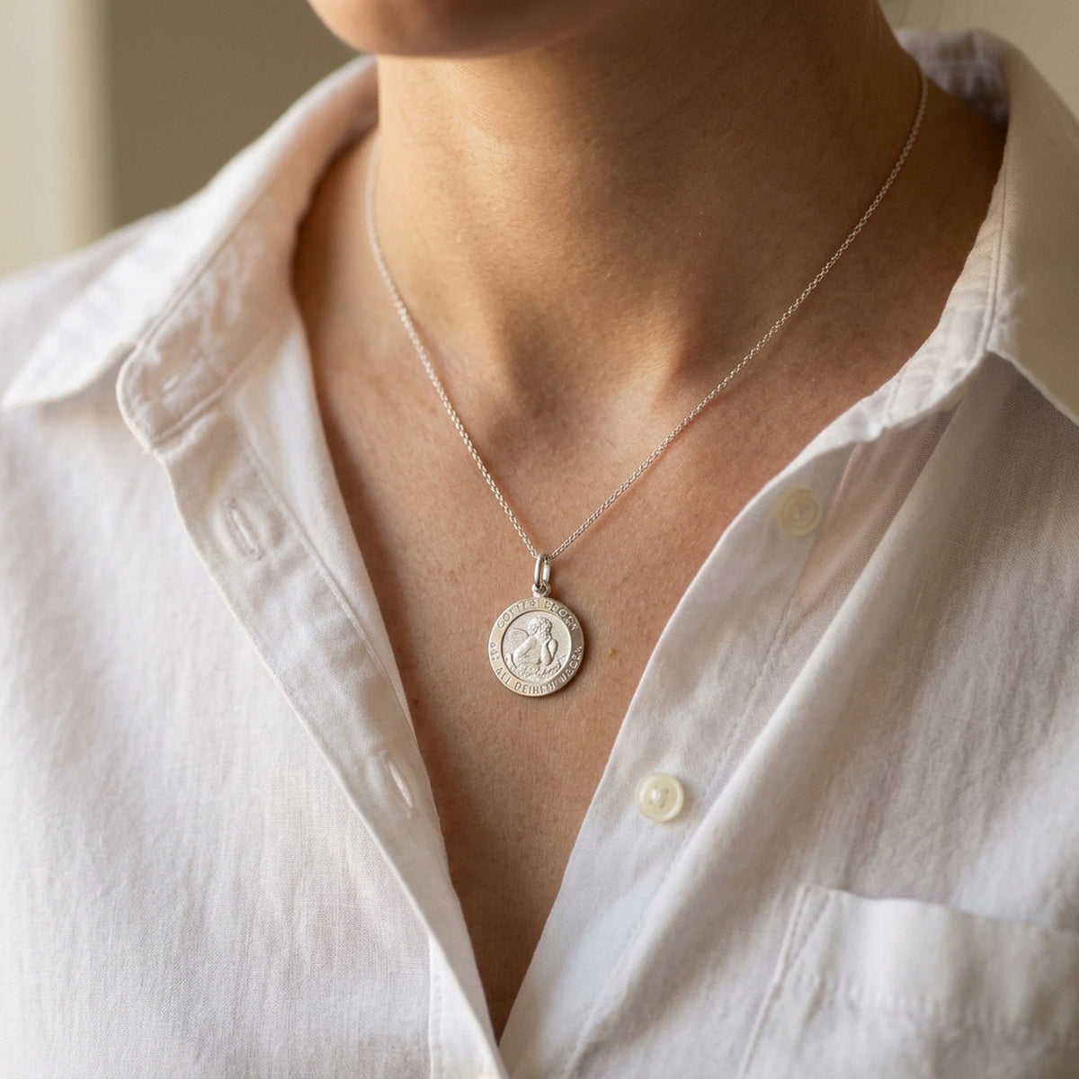 Anhänger Engel-Taufanhänger – 925er Silber, 12,5 mm – an einer feinen Kette getragen, natürliche Lifestyle-Aufnahme