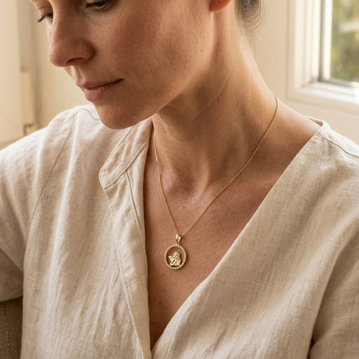 Anhänger Engelmotiv mit Zirkonia – 375er Gold, 14 mm – an einer feinen Kette getragen, zweite Lifestyle-Aufnahme in anderer Perspektive