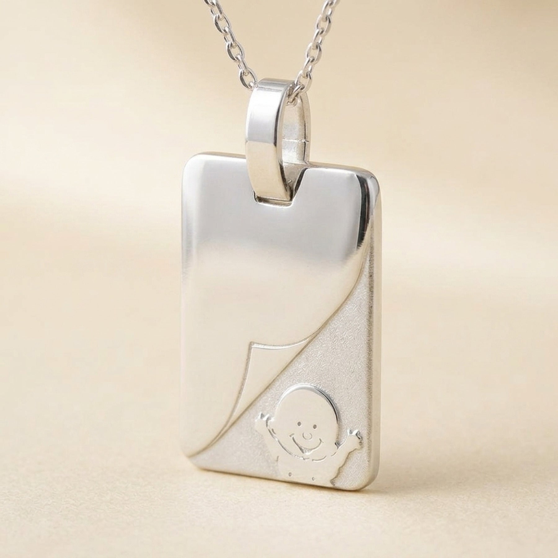 Anhänger Gravurplatte mit Baby matt-glänzend – 925er Silber, 19 × 14 mm – Detailansicht des Anhängers vor neutralem Hintergrund