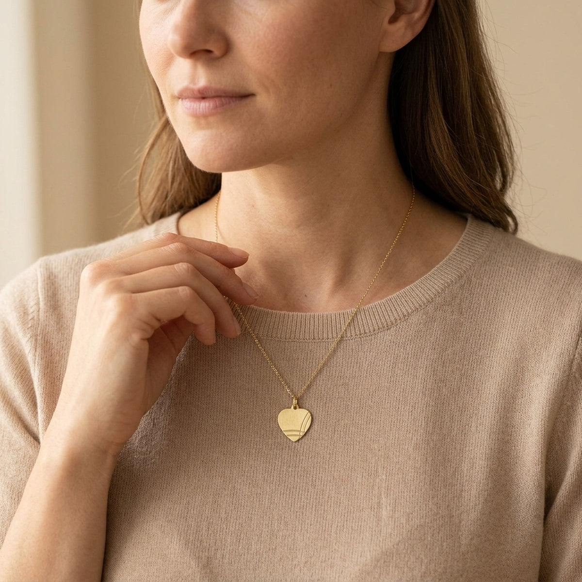 Anhänger Herz Gravuranhänger mattiert diamantiert – 375er Gold, 14 × 13 mm – an einer feinen Kette getragen, natürliche Lifestyle-Aufnahme