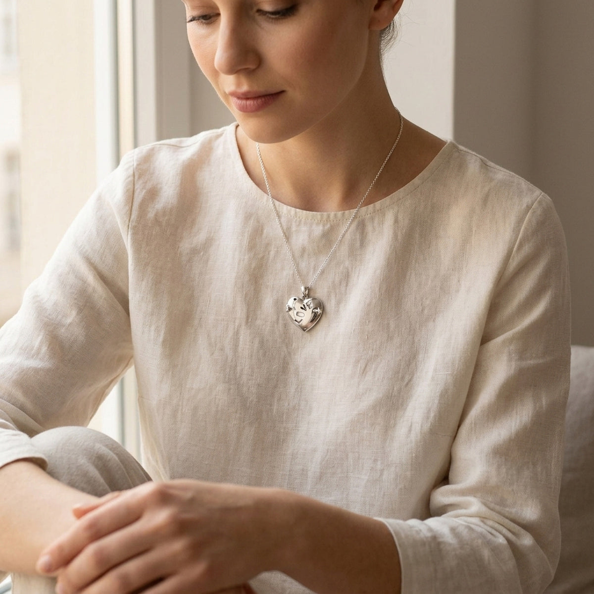 Anhänger Herz mit Pfeil und Inschrift „LOVE“ glänzend rhodiniert – 925er Silber, 21 × 21 mm – an einer feinen Kette getragen, zweite Lifestyle-Aufnahme in anderer Perspektive