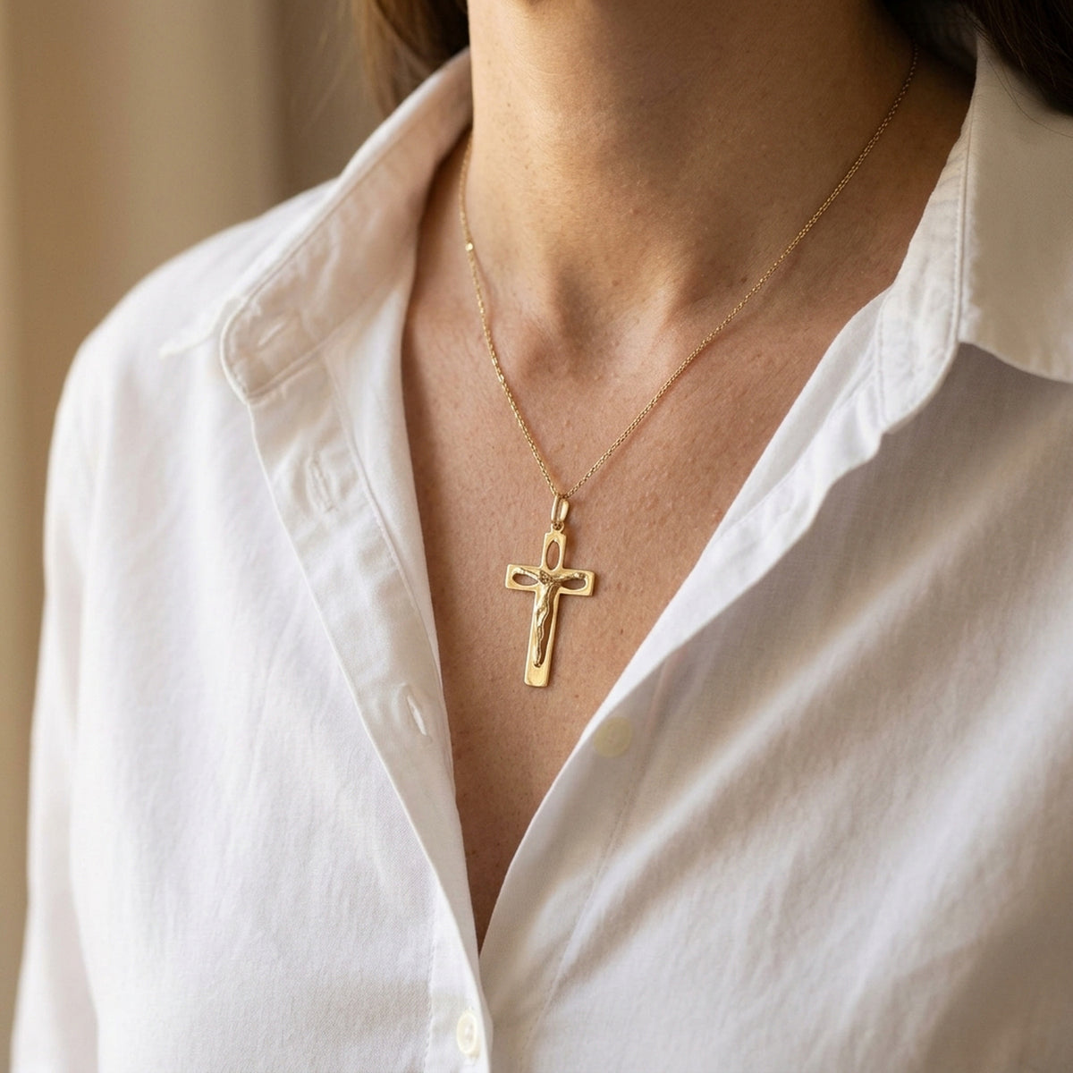 Anhänger Kreuz mit Jesus durchbrochen glänzend – 585er Gold, 28 × 17 mm – an einer feinen Kette getragen, natürliche Lifestyle-Aufnahme
