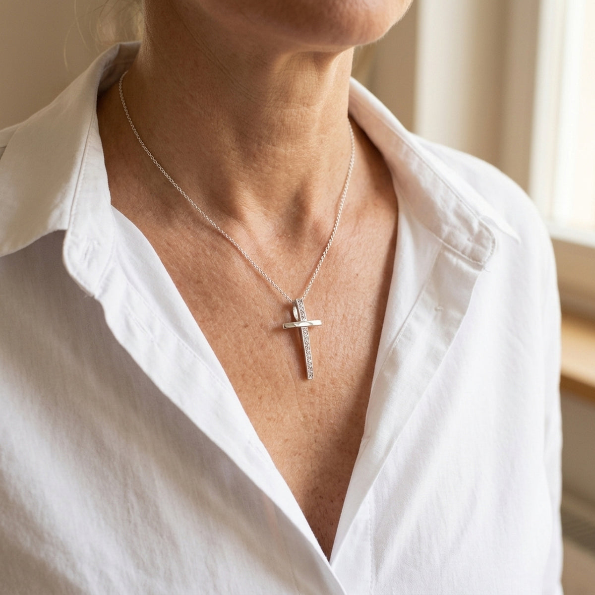Anhänger Kreuz mit Zirkonia – 925er Silber, 25 × 14 mm – an einer feinen Kette getragen, natürliche Lifestyle-Aufnahme