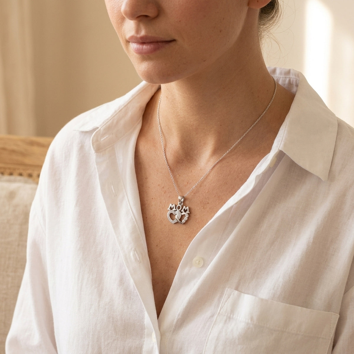 Anhänger MOM mit 2 Herzen und vielen Zirkonia rhodiniert – 925er Silber, 19 × 17 mm – an einer feinen Kette getragen, natürliche Lifestyle-Aufnahme