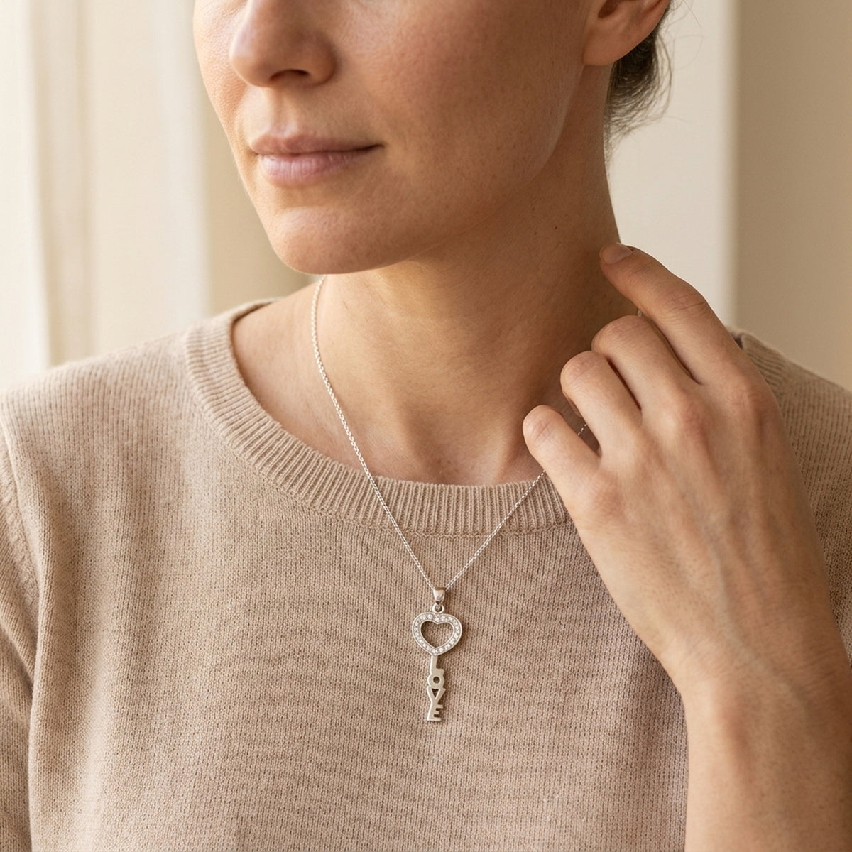 Anhänger Schlüssel LOVE mit Zirkonia glänzend – 925er Silber, 28 × 12 mm – an einer feinen Kette getragen, natürliche Lifestyle-Aufnahme