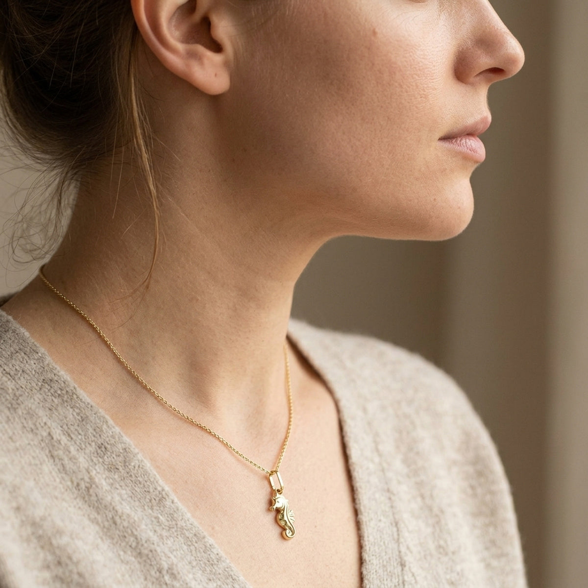 Anhänger Seepferdchen glänzend – 375er Gold, 14 × 7 mm – an einer feinen Kette getragen, zweite Lifestyle-Aufnahme in anderer Perspektive