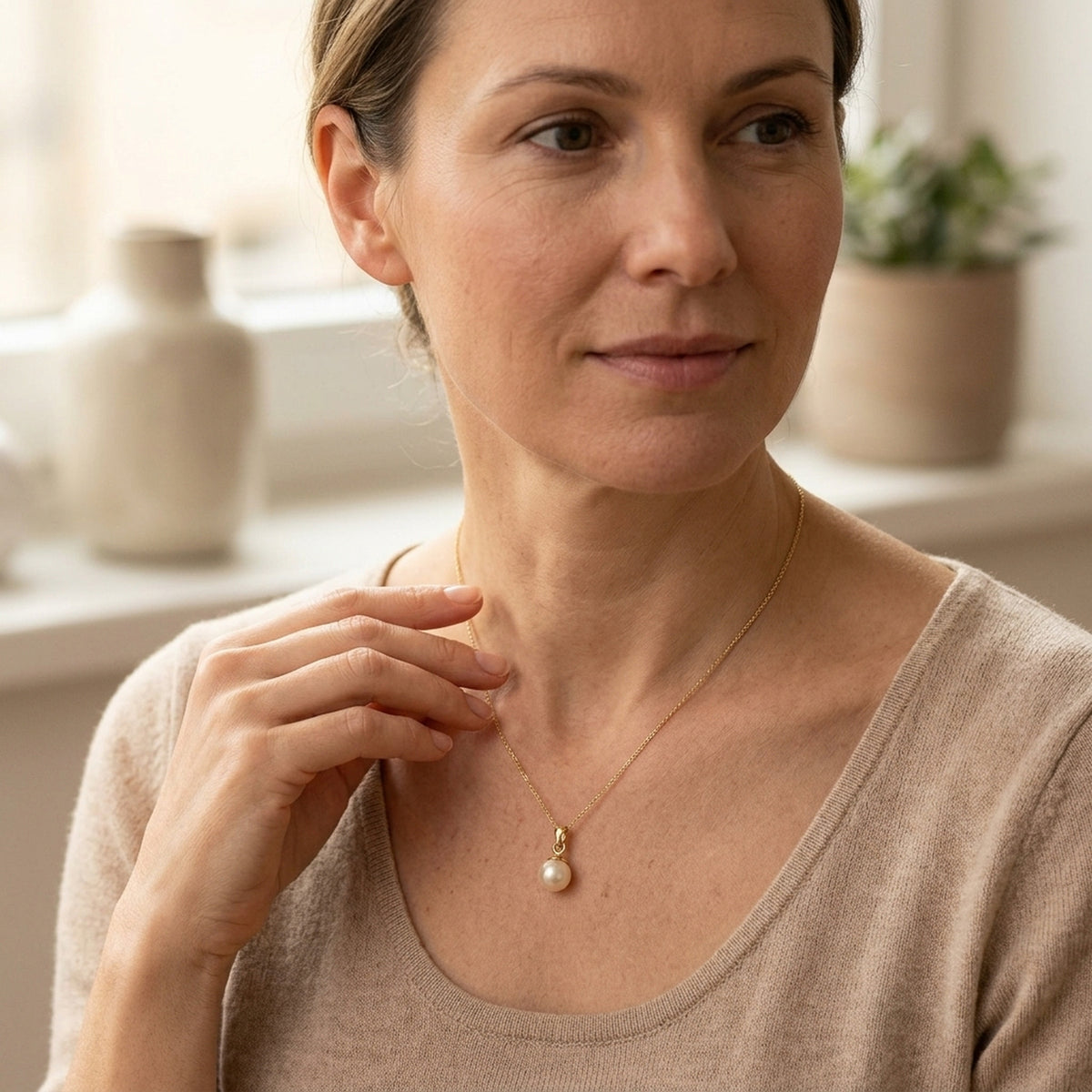 Anhänger Süßwasserperle rund – 375er Gold, ca. 6 mm – an einer feinen Kette getragen, natürliche Lifestyle-Aufnahme