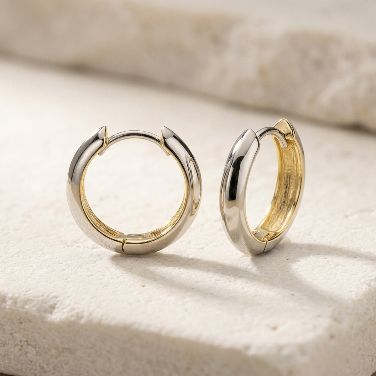 Creolen bicolor durchlegiert – 375er Gelb- und Weißgold, 14 × 3 mm – Detailansicht des Ohrschmucks vor neutralem Hintergrund