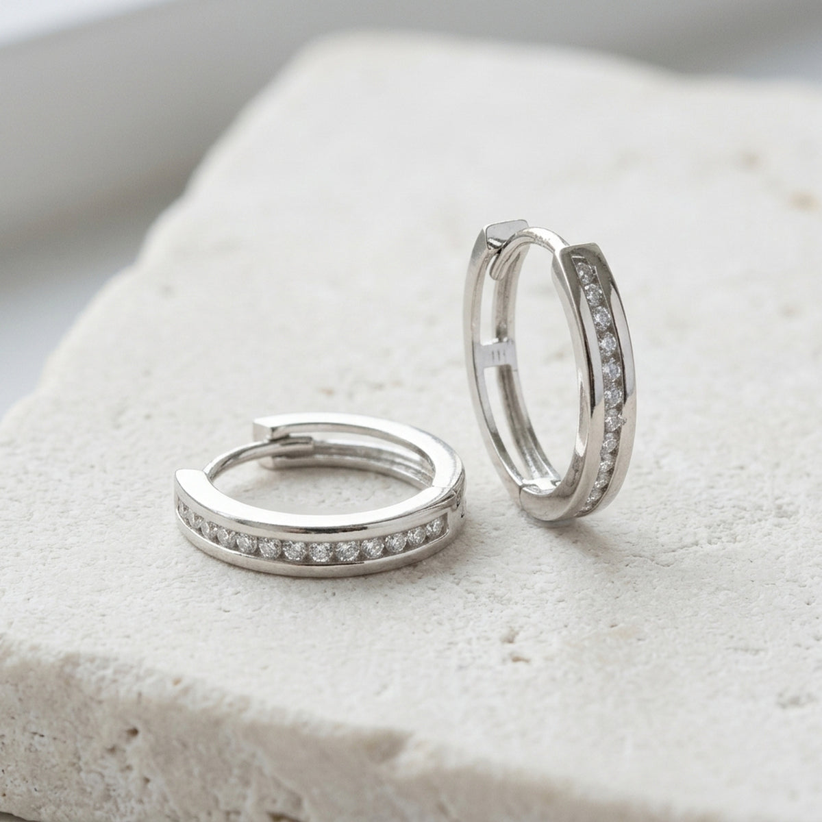 Creolen mit Zirkonia – 375er Weißgold, 14 × 3 mm – Detailansicht des Ohrschmucks vor neutralem Hintergrund