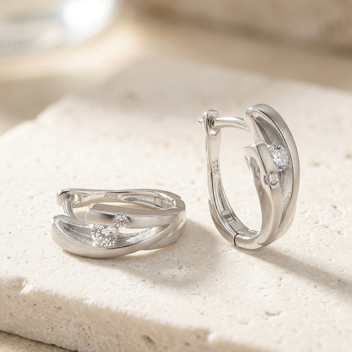 Creolen mit Zirkonia matt-glänzend rhodiniert – 925er Silber, 14 × 5 mm – Detailansicht des Ohrschmucks vor neutralem Hintergrund
