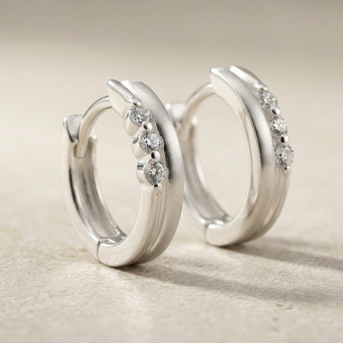 Creolen mit Zirkonia matt-glänzend – 925er Silber, 13 × 3 × 4 mm – Detailansicht des Ohrschmucks vor neutralem Hintergrund