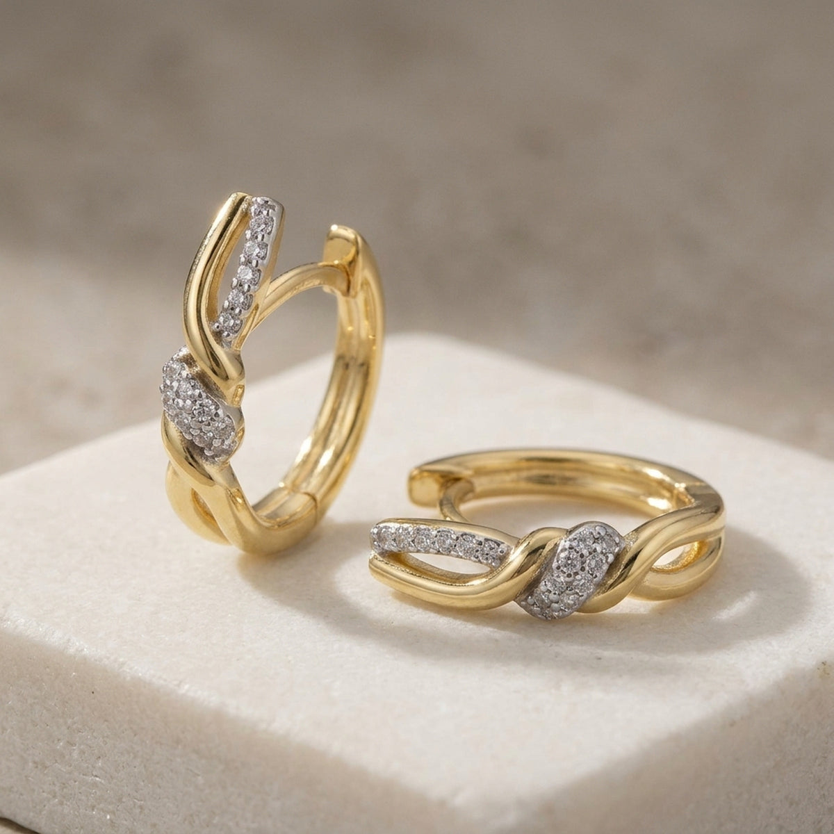 Überkreuzte Creolen mit Zirkonia – 375er Gold, 18 × 4 mm – Detailansicht des Ohrschmucks vor neutralem Hintergrund