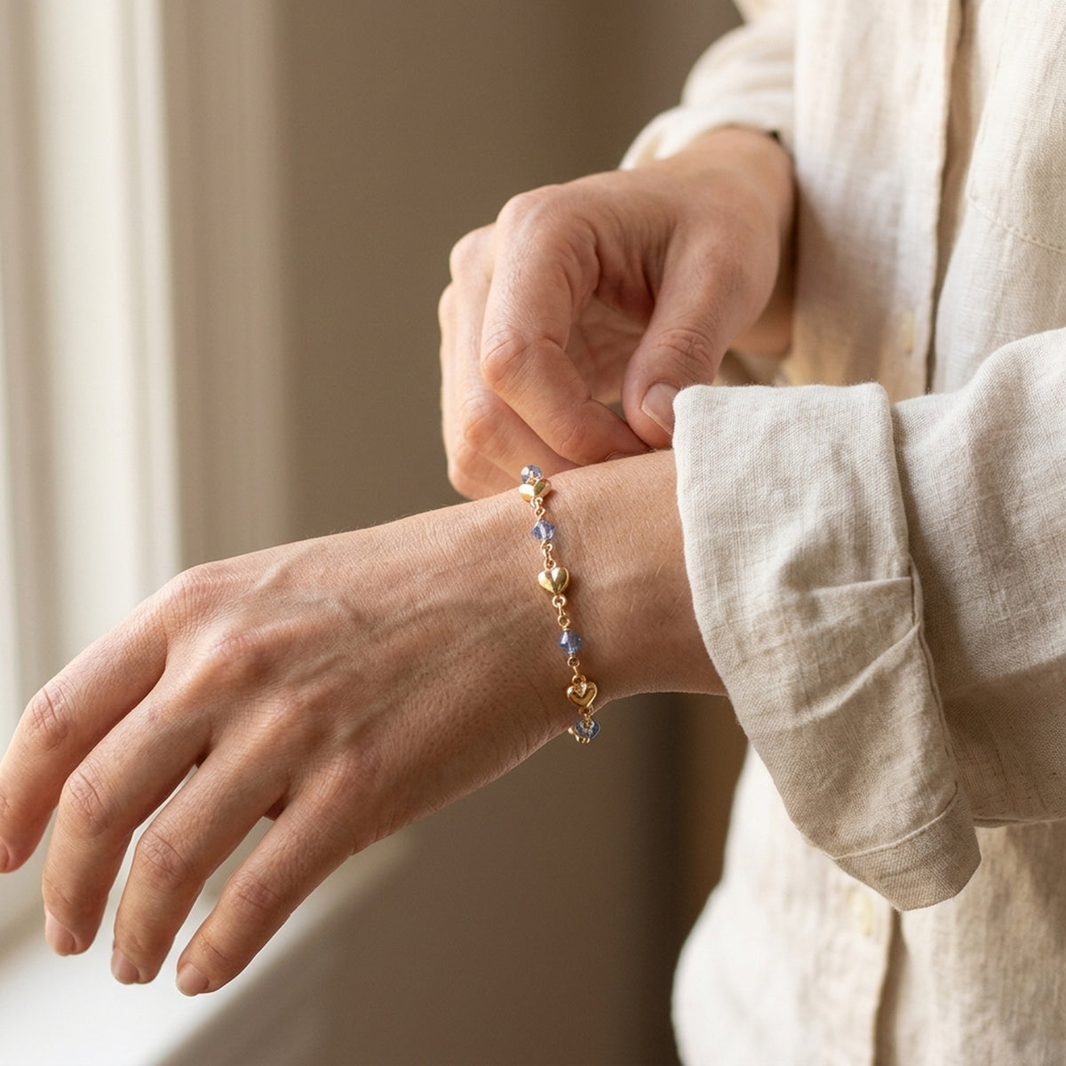 Armband mit Herz und blauer Glasperle – Doublé, 5 mm, 19 cm – am Handgelenk getragen, zweite Lifestyle-Aufnahme in anderer Perspektive