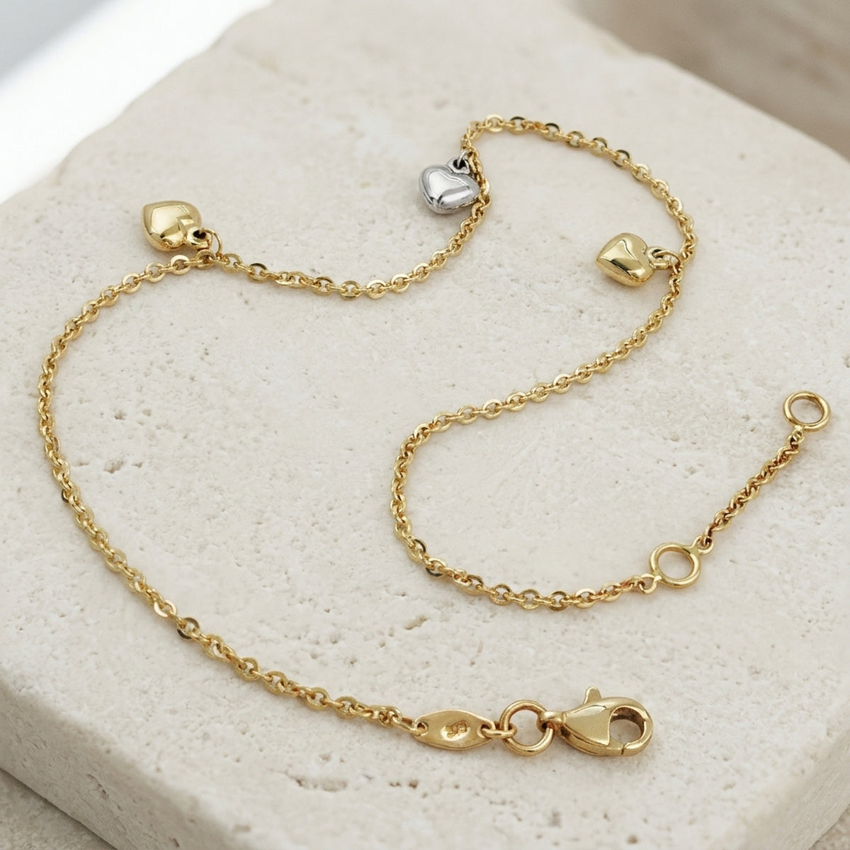Fußkette Ankerkette mit 3 Herzen bicolor längenvariabel – 375er Gelb- und Weißgold, 1,7 mm, 25 cm – Detailansicht des Fußkettes vor neutralem Hintergrund