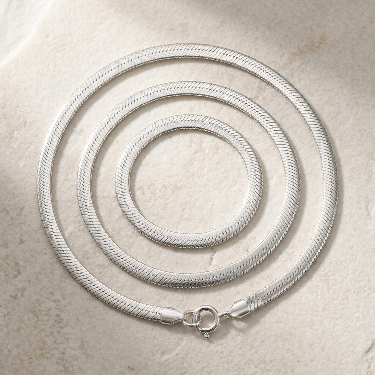 Flache Schlangenkette glänzend – 925er Silber, 4 mm, 38–50 cm – Detailansicht des Kettes vor neutralem Hintergrund