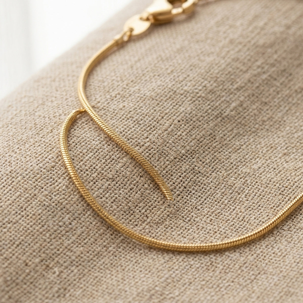 Runde Schlangenkette glänzend – 333er Gold, 1 mm – Detailansicht des Kettes vor neutralem Hintergrund