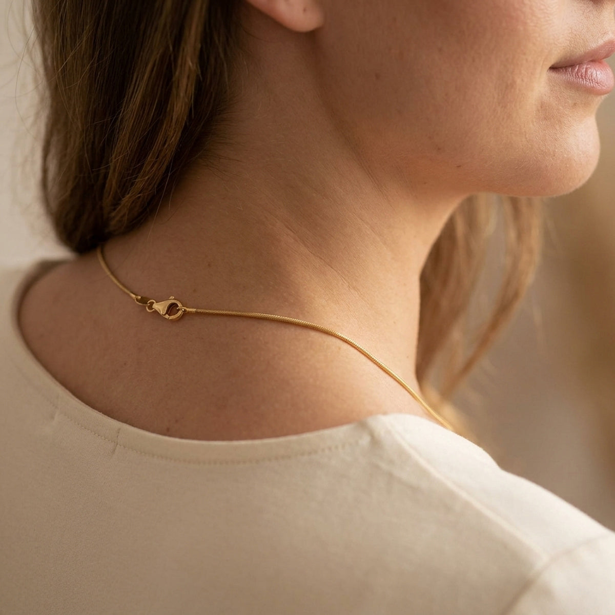 Runde Schlangenkette glänzend – 333er Gold, 1 mm – am Hals getragen, zweite Lifestyle-Aufnahme in anderer Perspektive
