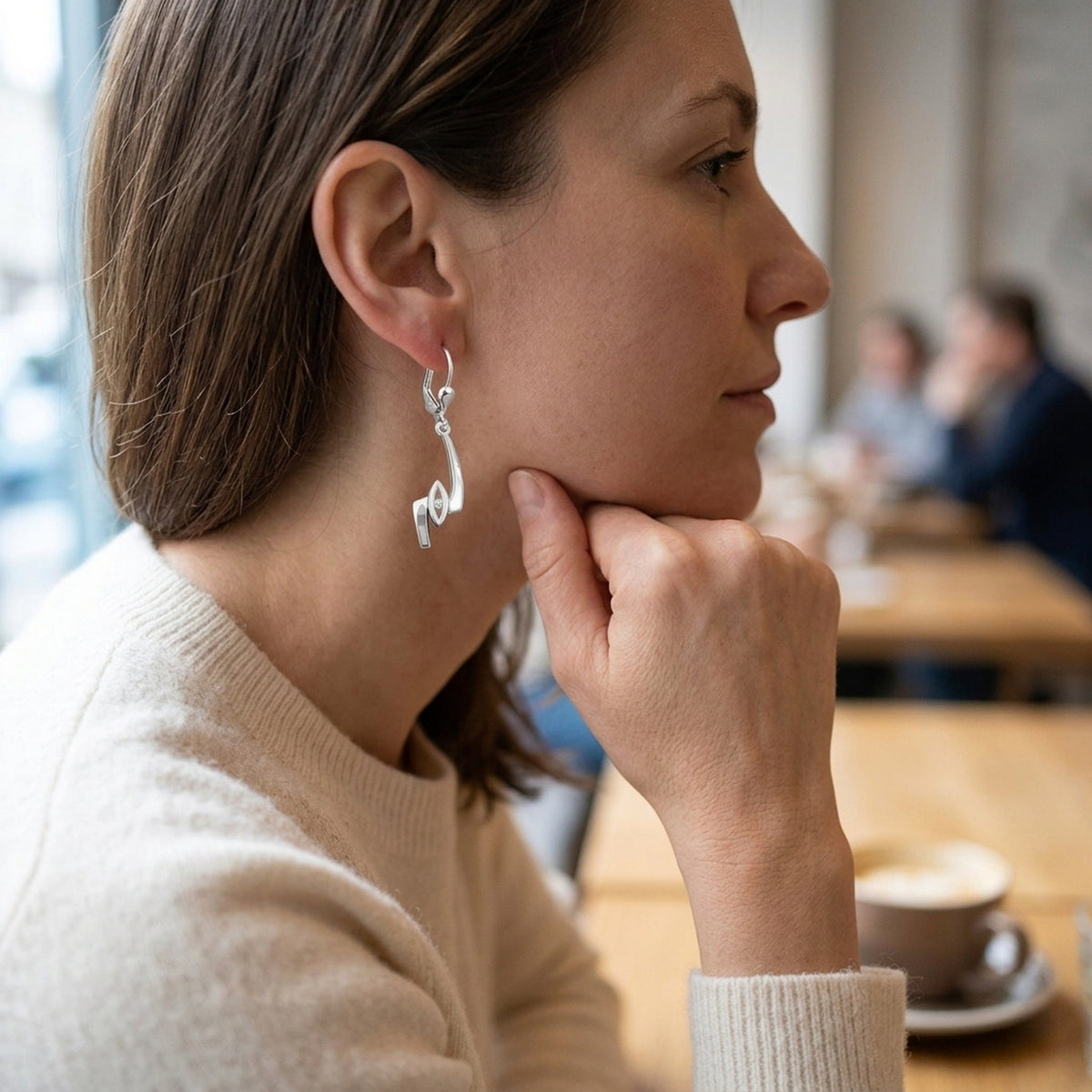 Ohrhänger Zickzack mit Zirkonia glänzend – 925er Silber, 36 × 8 mm – am Ohr getragen, zweite Lifestyle-Aufnahme in anderer Perspektive