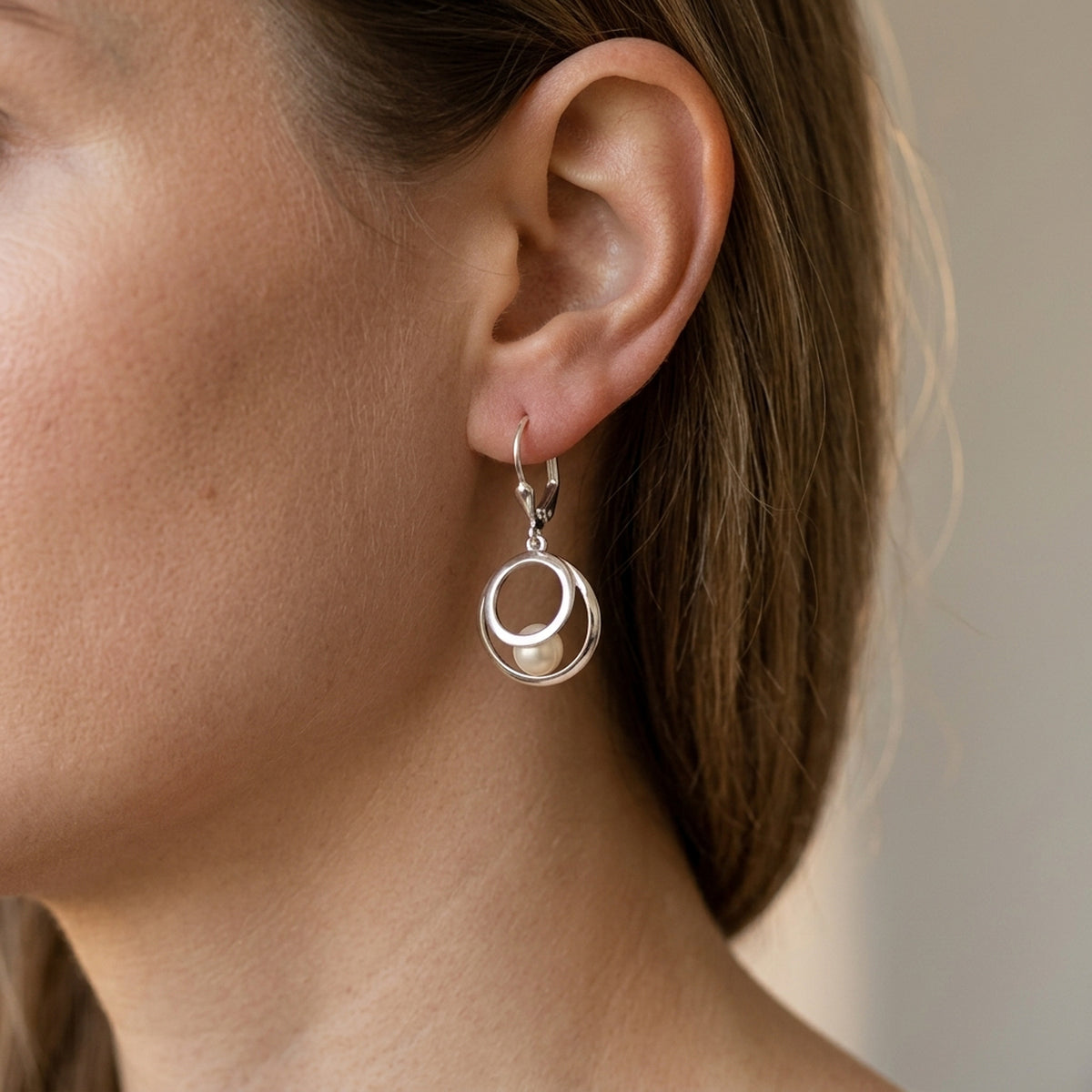 Ohrhänger 2 Kreise mit Süßwasserperle – 925er Silber, 30 × 13 mm – am Ohr getragen, zweite Lifestyle-Aufnahme in anderer Perspektive
