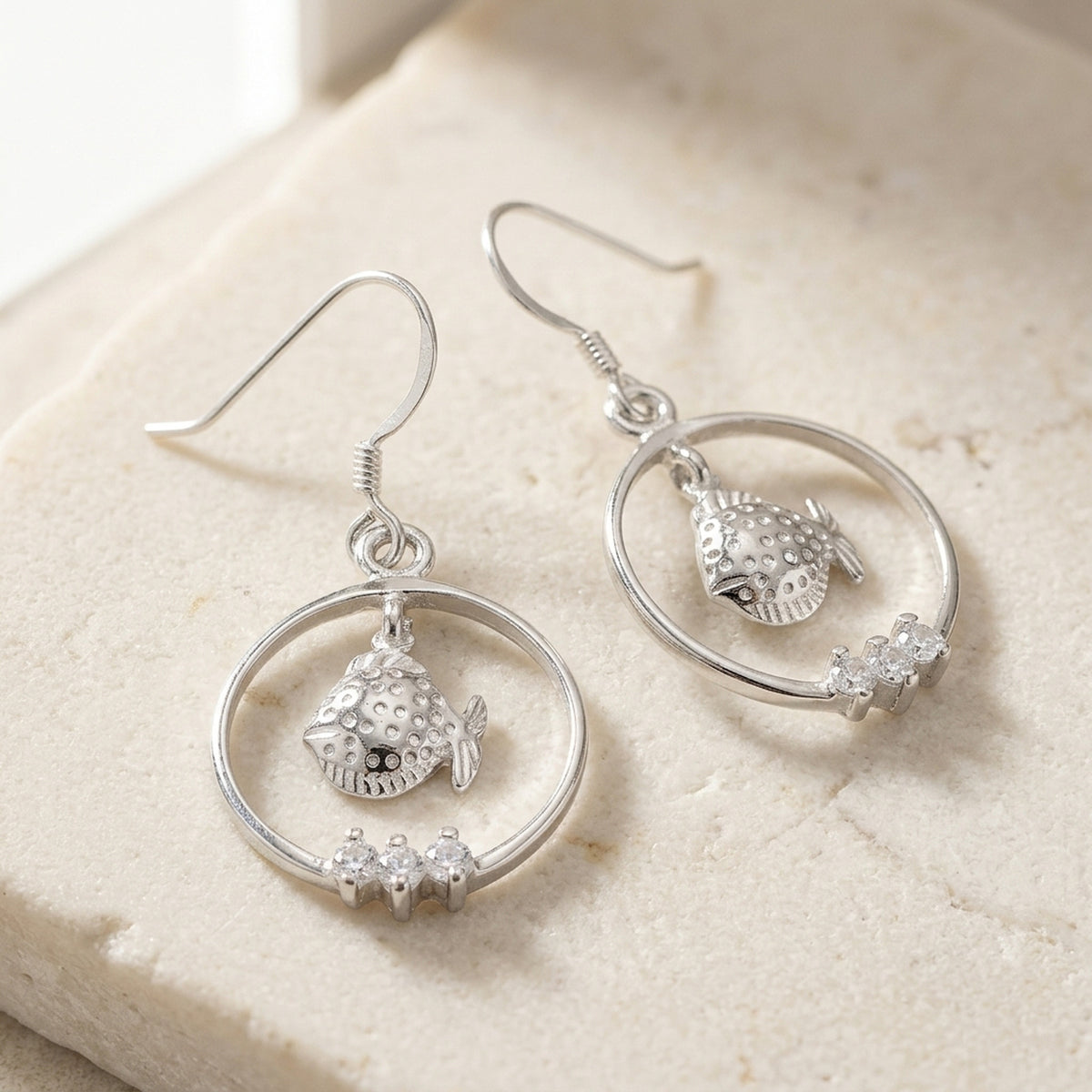 Ohrringe Fisch im Ring mit Zirkonia glänzend rhodiniert – 925er Silber, 37 × 18 mm – Detailansicht des Ohrschmucks vor neutralem Hintergrund