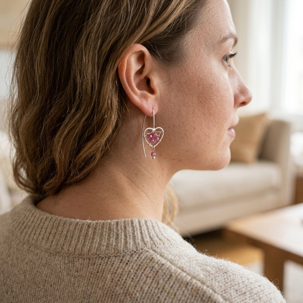 Ohrringe Herz mit Geflecht und rosa Glassteinen – 925er Silber, 33 × 10,5 mm – am Ohr getragen, natürliche Lifestyle-Aufnahme