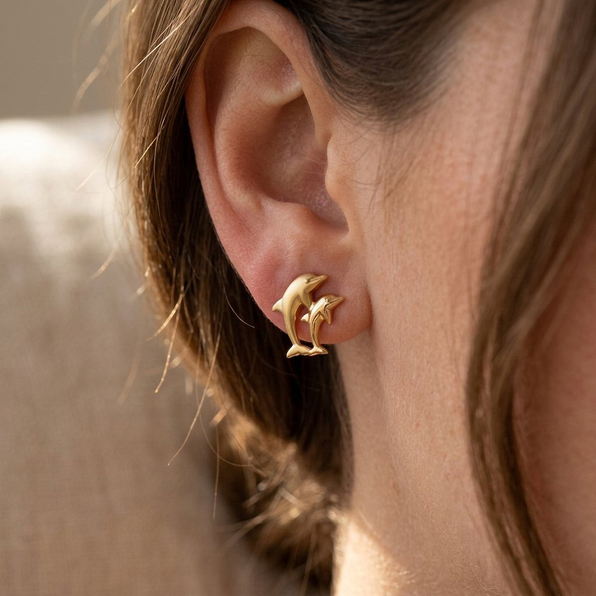 Ohrstecker Delfin-Pärchen matt-glänzend – 375er Gold, 10 × 7 mm – am Ohr getragen, zweite Lifestyle-Aufnahme in anderer Perspektive