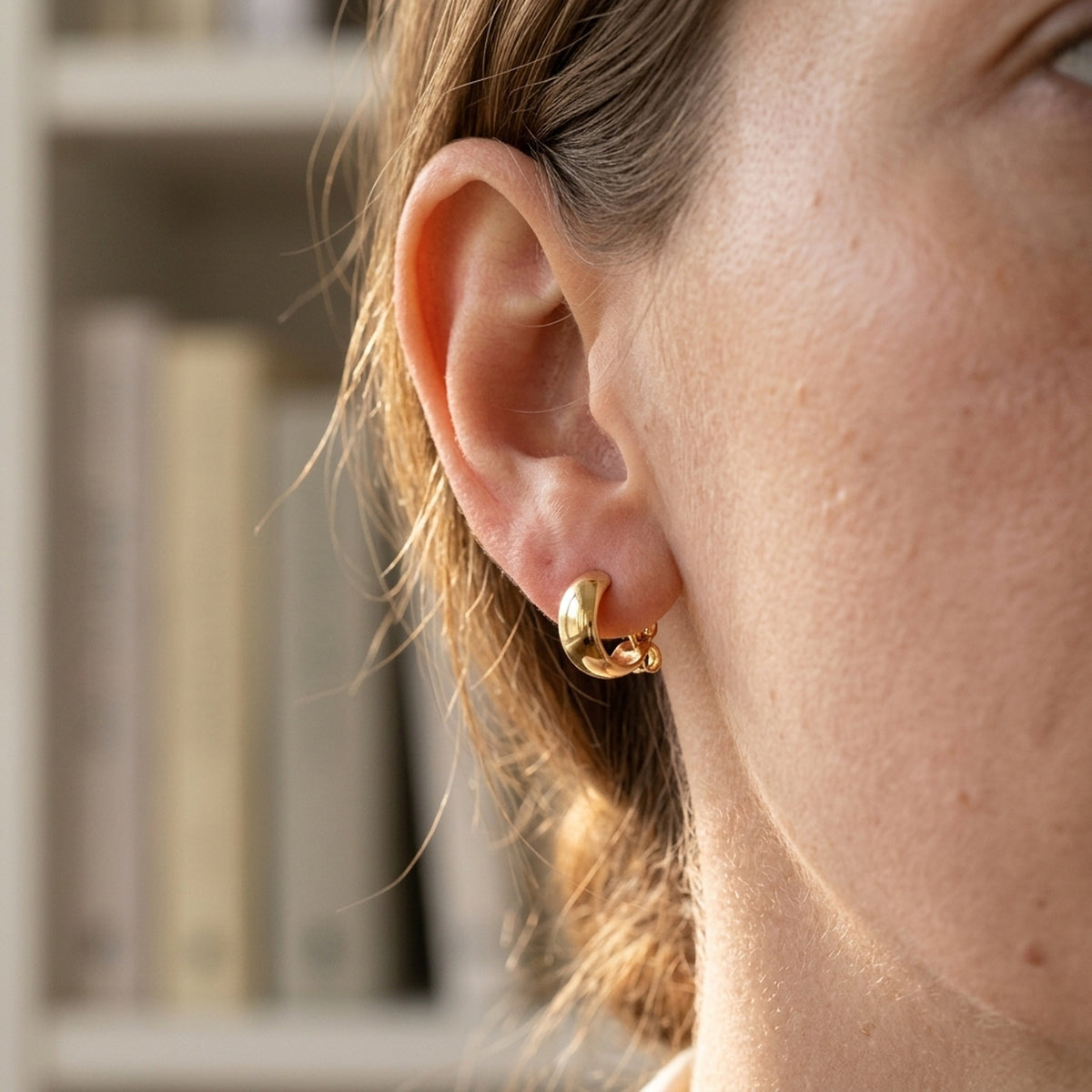 Ohrstecker Flügel – 375er Gold, 5 mm – am Ohr getragen, zweite Lifestyle-Aufnahme in anderer Perspektive