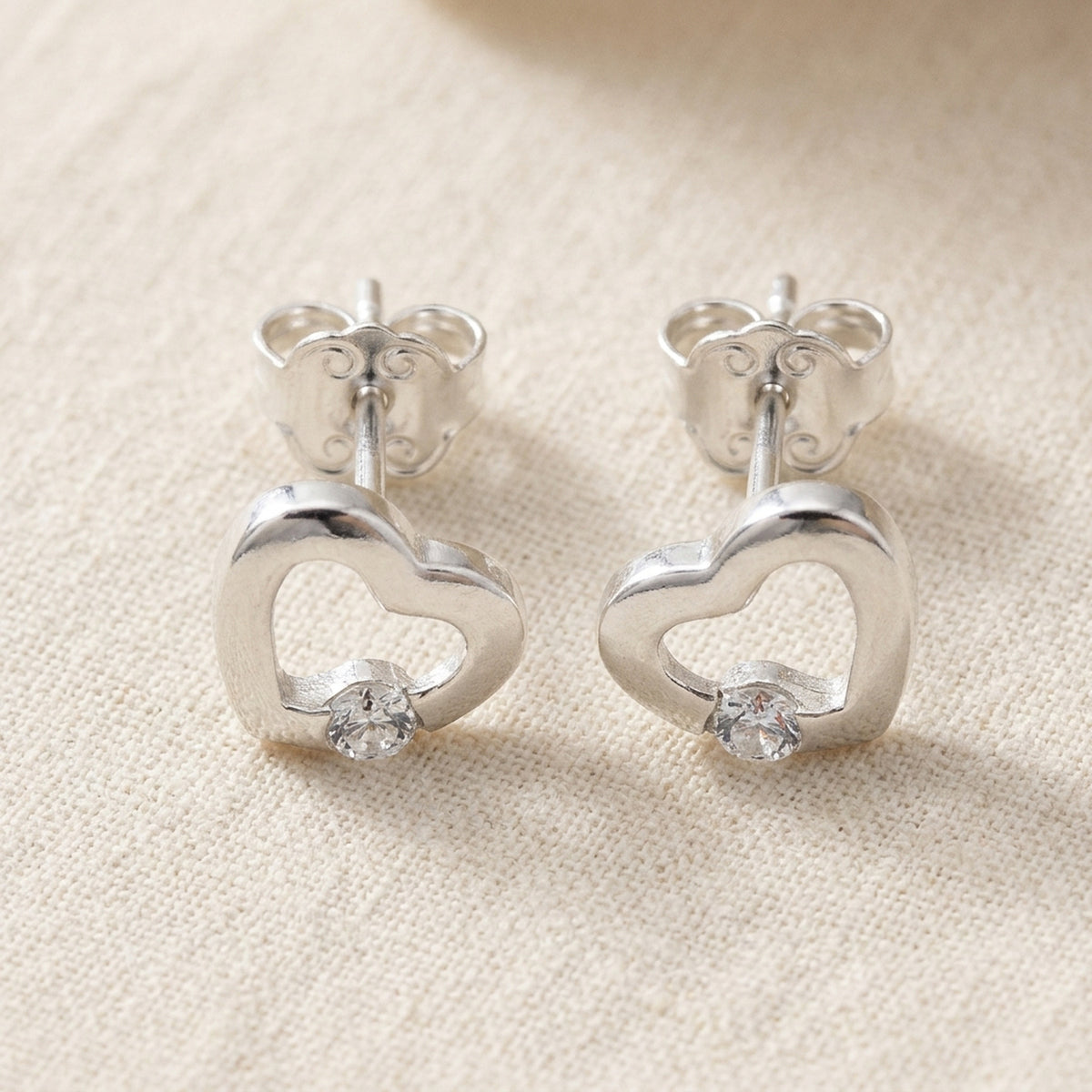 Ohrstecker Herz mit Zirkonia glänzend – 925er Silber, 7 × 8 mm – Detailansicht des Ohrschmucks vor neutralem Hintergrund
